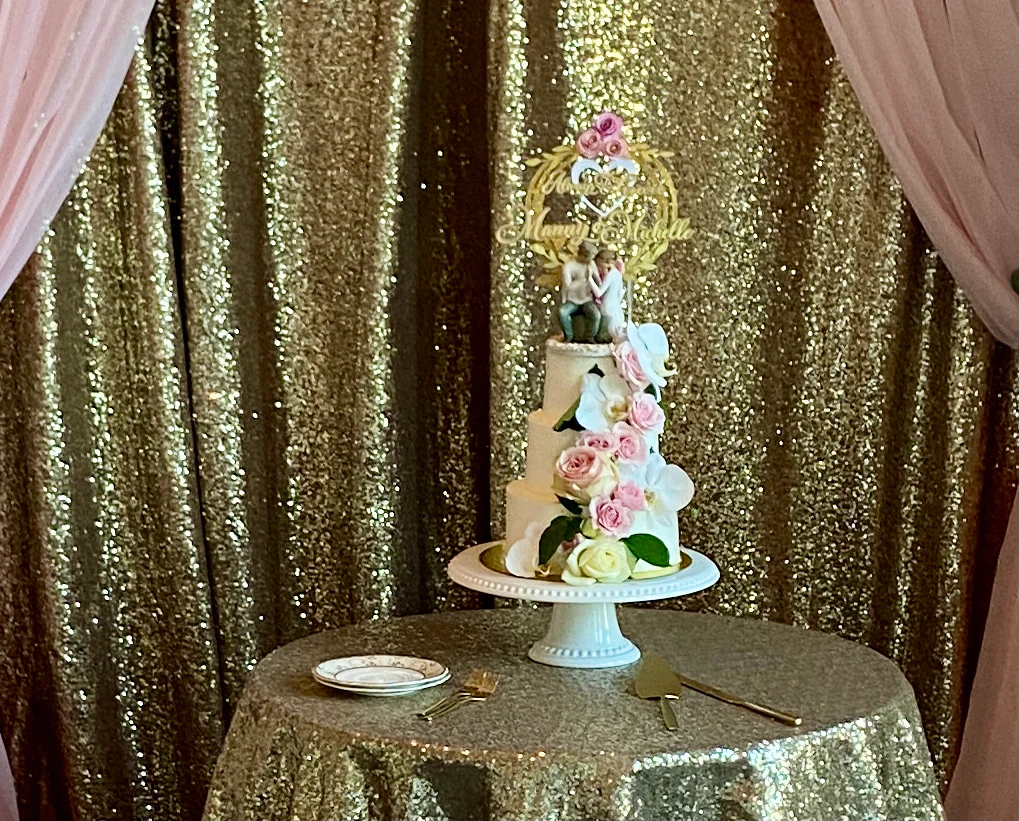 A cake on top of a table with gold sequins.