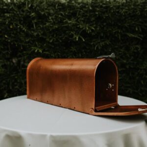 A brown leather mailbox sitting on top of a table.