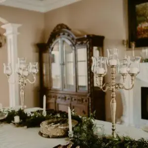 A dining room with candles and wreaths on the table.