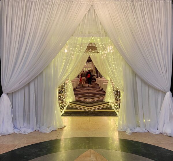 A room with white curtains and lights on the walls