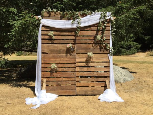 A wooden wall with flowers hanging from it.