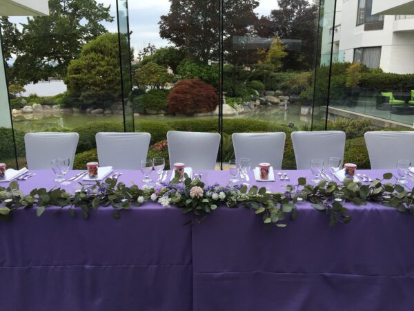 A purple table with flowers and candles on it