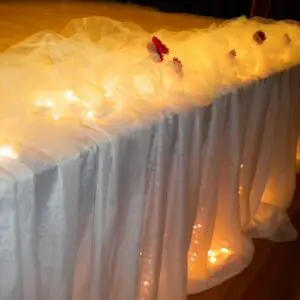 A table with lights and white cloth on it