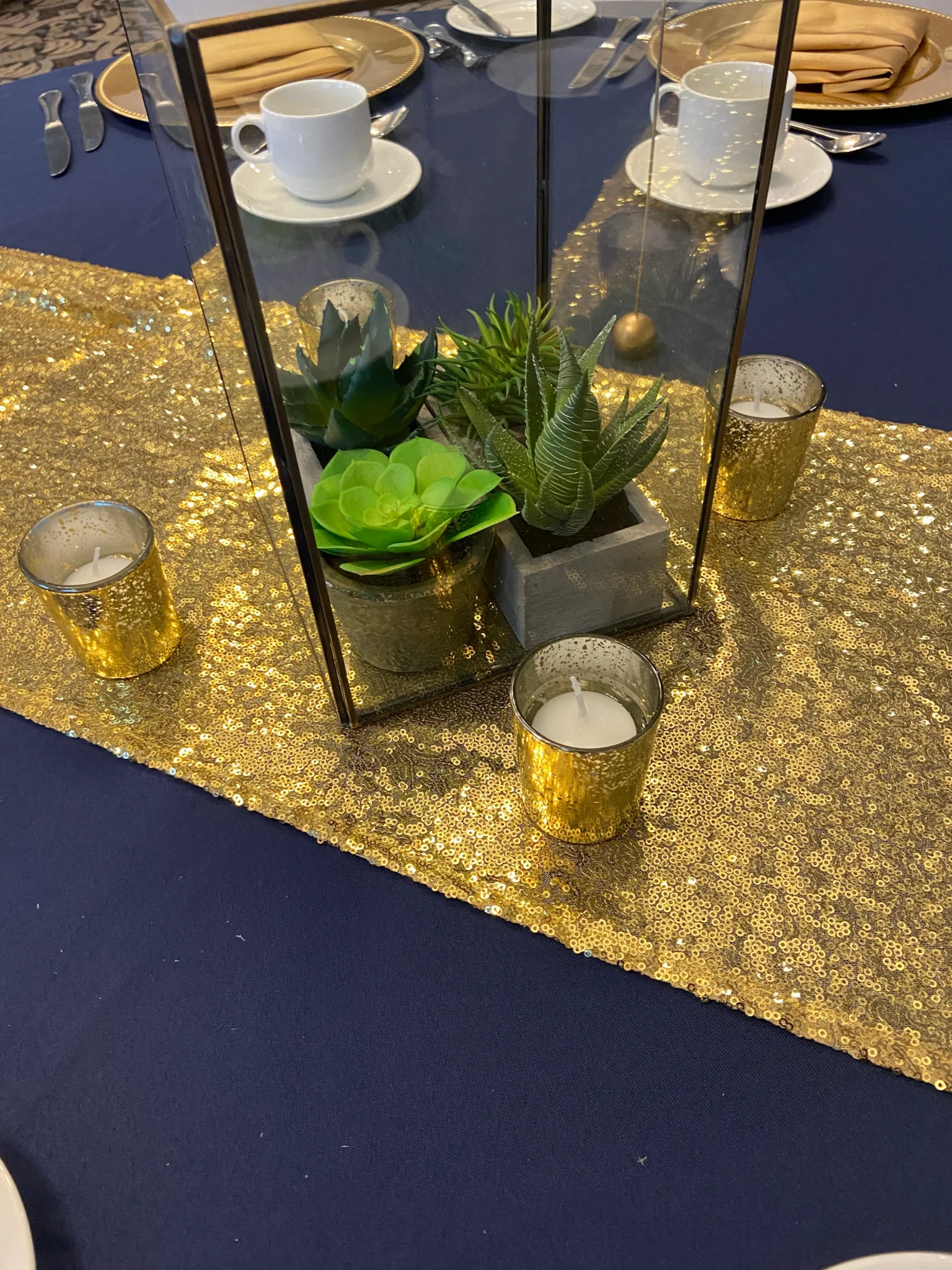 A table with gold sequins and candles on it