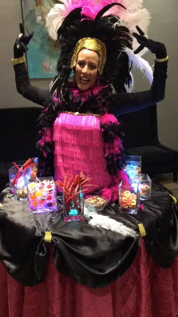 A woman in pink dress sitting on top of table.