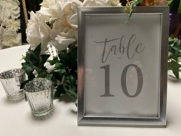 A table with a glass and flowers on it