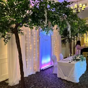 A table with a white cloth and two trees