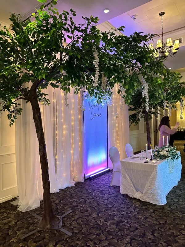 A table with a white cloth and two trees