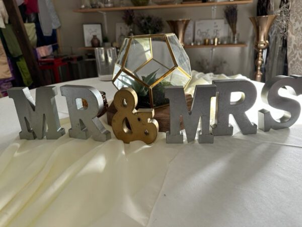 A table with a mirror and two wooden letters