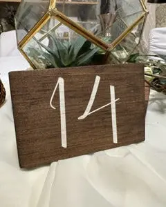 A table number with the numbers 1 4 and 1 5 on it.