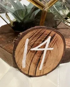 A wooden slice with the number 1 4 painted on it.