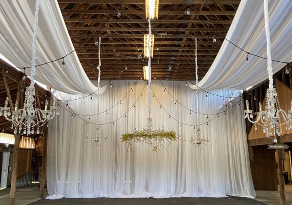 A room with white curtains and lights hanging from the ceiling.