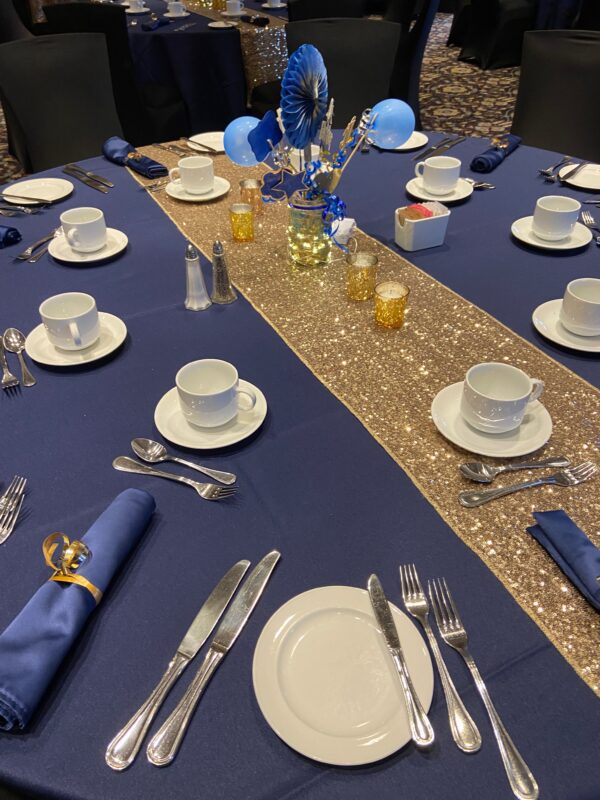 A table set with plates, cups and silverware.