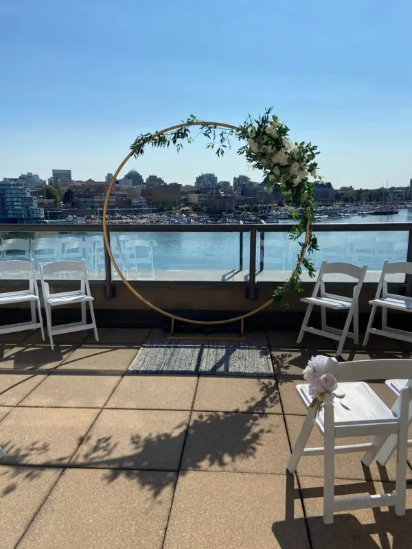 A circular wedding arch with flowers on top of it.