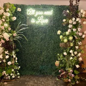 A green wall with white flowers and plants