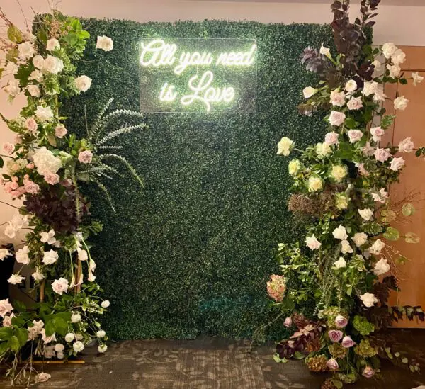 A green wall with white flowers and plants