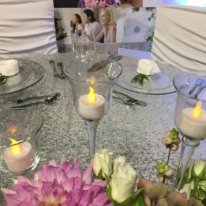 A table set with candles and flowers on it.