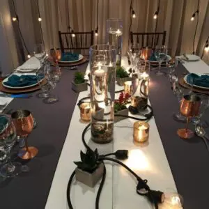 A table set with candles and wine glasses.