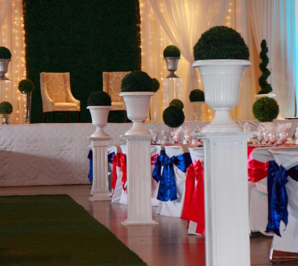 A room with many white pillars and some red, blue and white decorations.