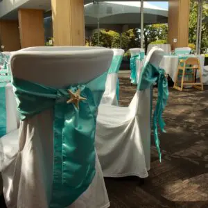 A white chair with blue ribbon and starfish on the back.