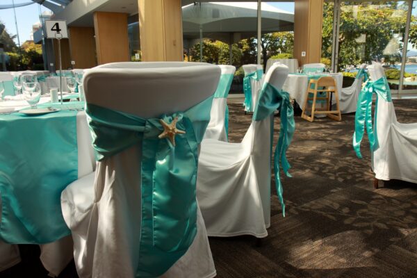 A white chair with blue ribbon and starfish on the back.