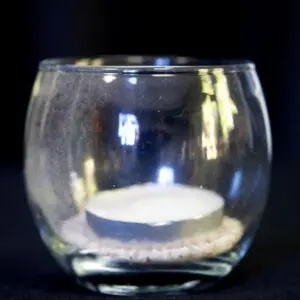 A candle in a glass bowl on the table