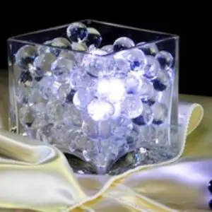 A glass vase with white lights inside of it