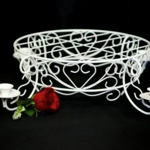 A white bowl with roses and candles on it