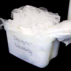 A container of white fabric with the words " designer wedding ".