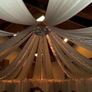 A ceiling with lights and drapes in the center.