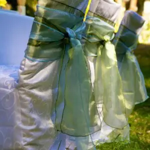 A close up of the back of a chair with green ribbons