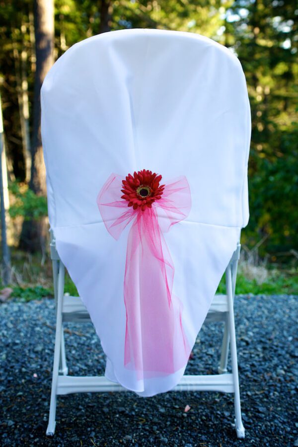 A chair with a pink bow and flower on it.