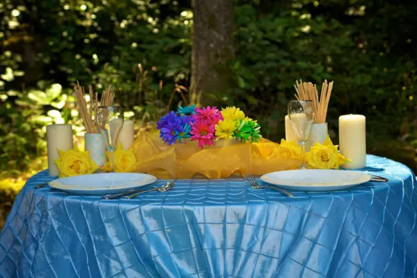 A table with two plates and flowers on it.