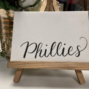 A small easel with a sign that says phillies