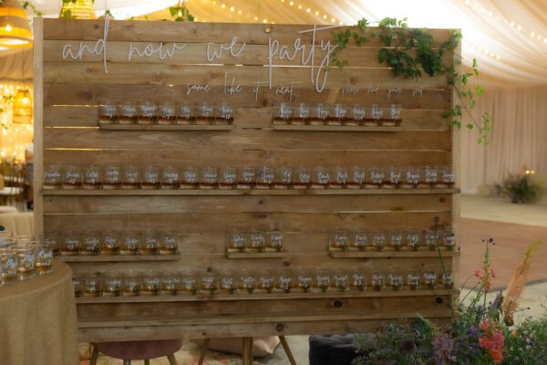 A wooden wall with many jars on it