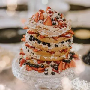 A cake with strawberries and whipped cream on top.