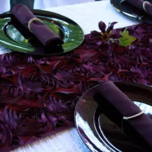 A table set with purple napkins and plates.