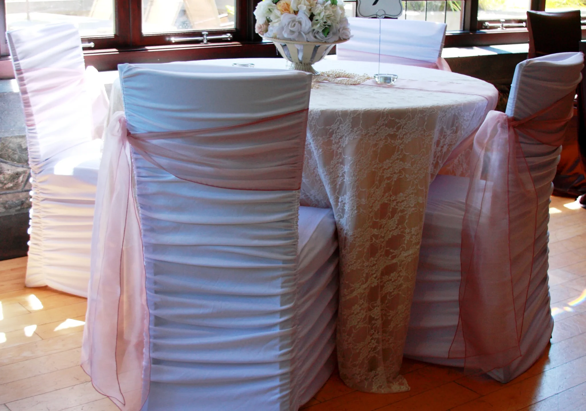 A table with two chairs and a vase of flowers.