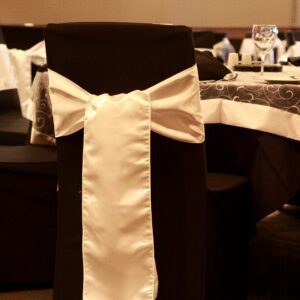 A black chair with white bow on it