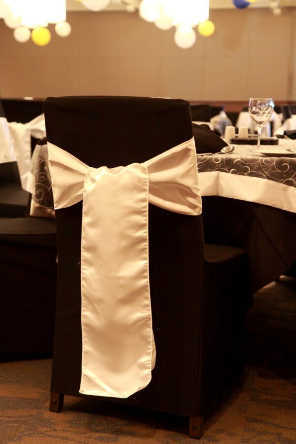 A black chair with white bow on it