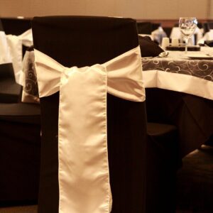 A black chair with white bow on it