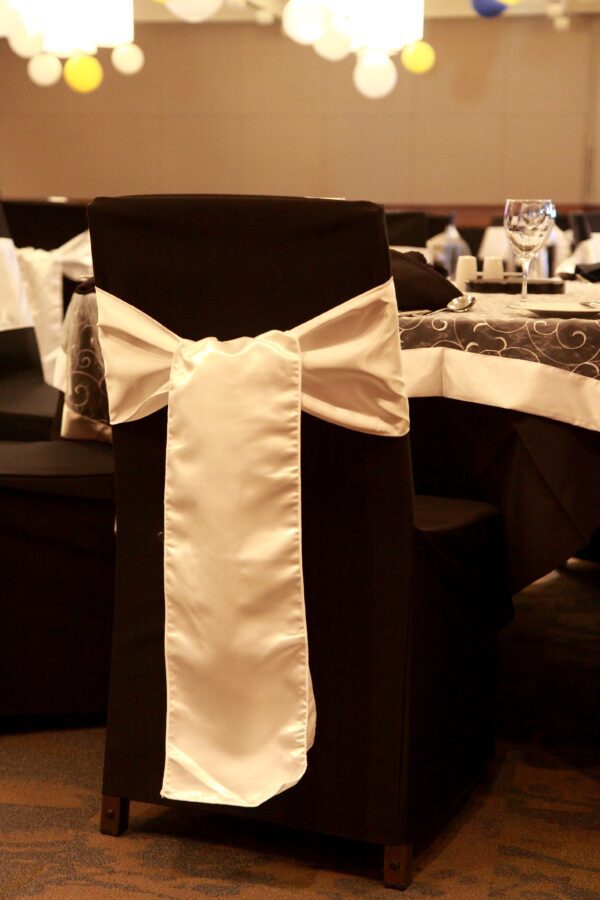 A black chair with white bow on it