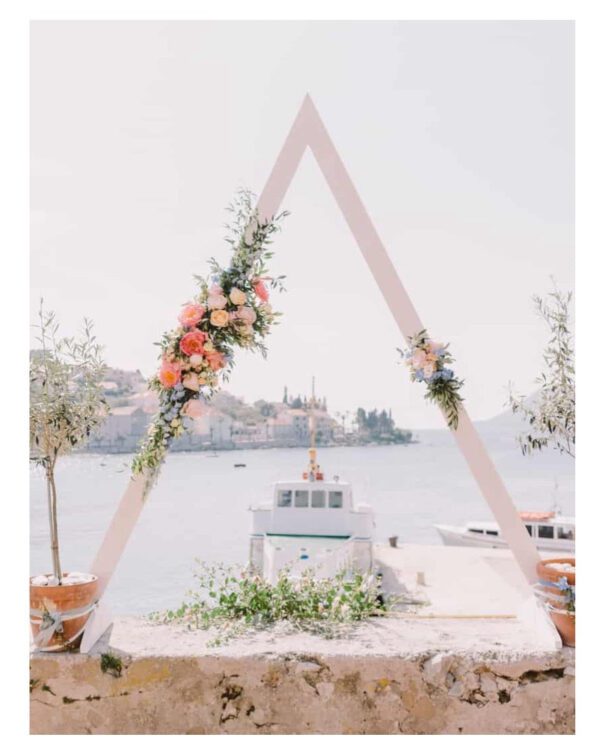 A white triangle with flowers on top of it.