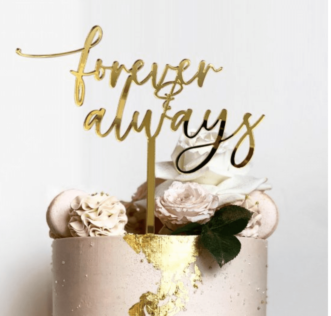 A cake with gold lettering on top of it.