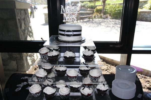 A cake and cupcakes display on top of a table.