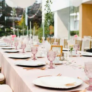 A long table with pink plates and glasses