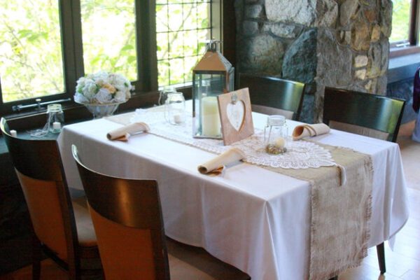 A table set with white linens and a candle.