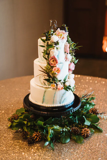 A three tiered cake with flowers on top of it.