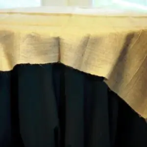 A table with black cloth and beige linen.