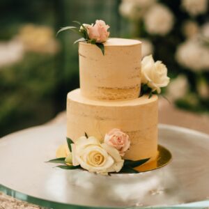 A two layer cake with flowers on top of it.
